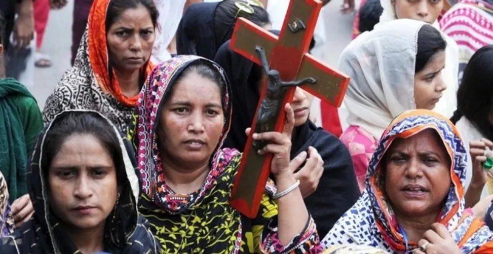 Donne cristiane con il capo velato manifestano reggendo un crocifisso