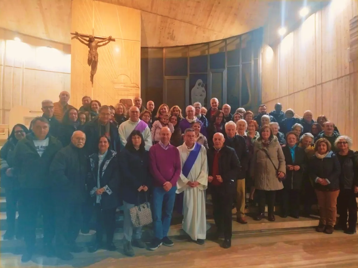 Foto di gruppo dei partecipanti agli esercizi spirituali sotto il crocifisso della chiesa