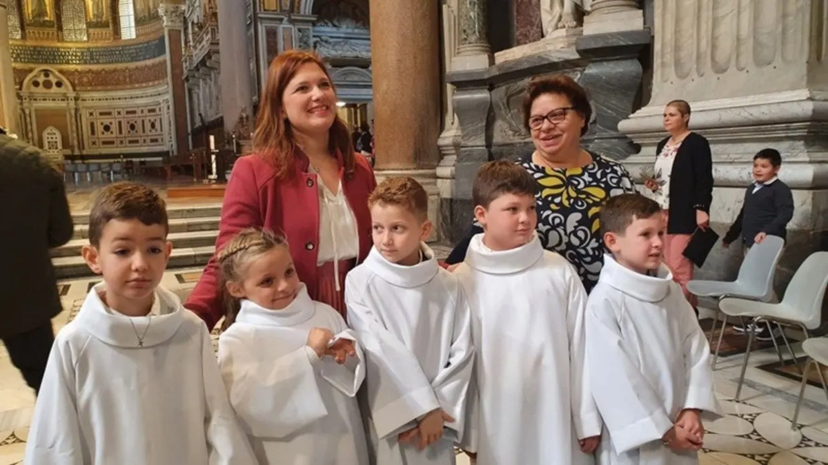 Giovani ministranti in tunica bianca con le catechiste all'interno di una basilica