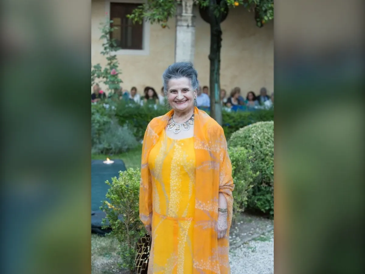 La pianista Marcella Crudeli in abito giallo nel giardino di un chiostro