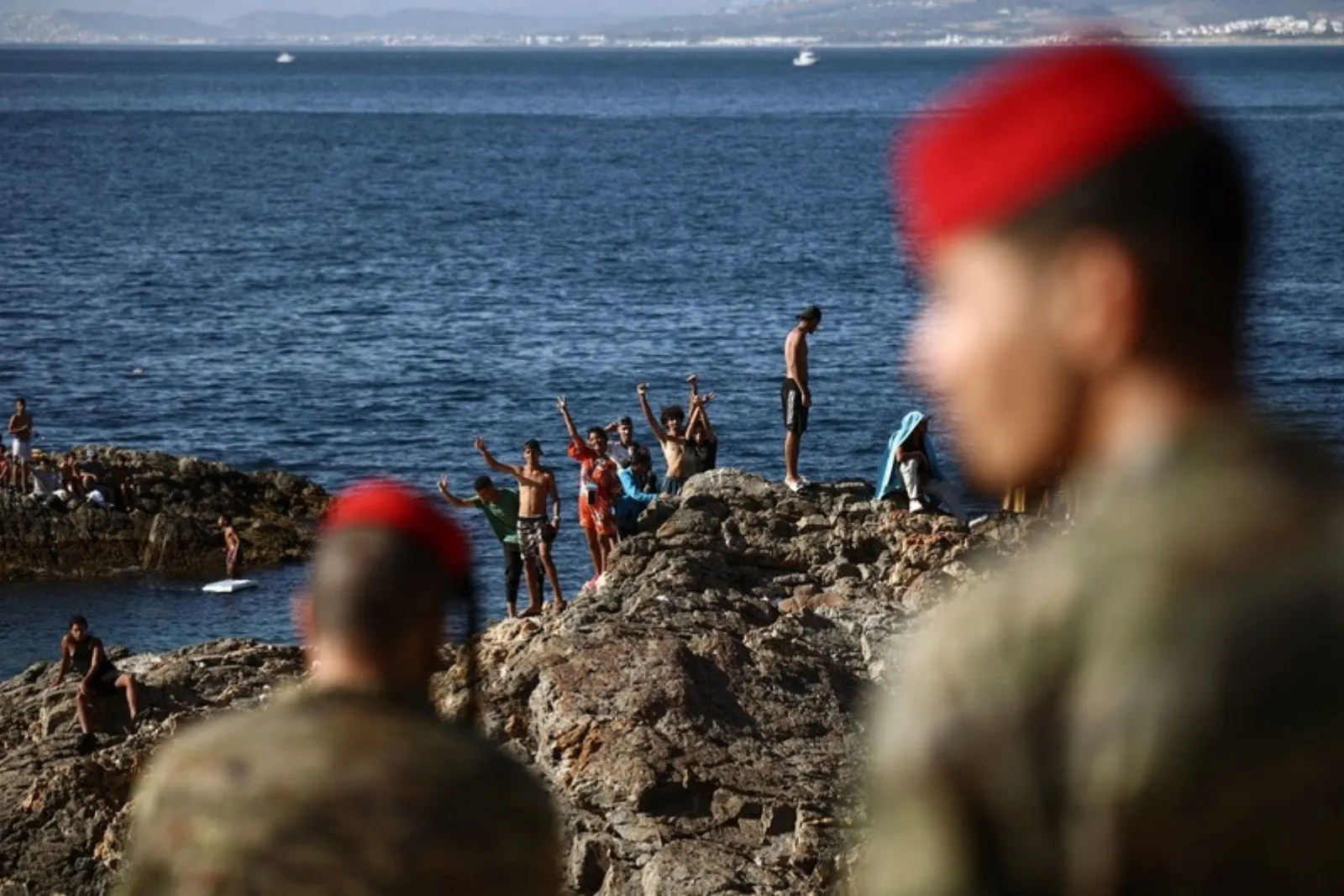 Migranti sugli scogli al confine di Ceuta sorvegliati dai militari