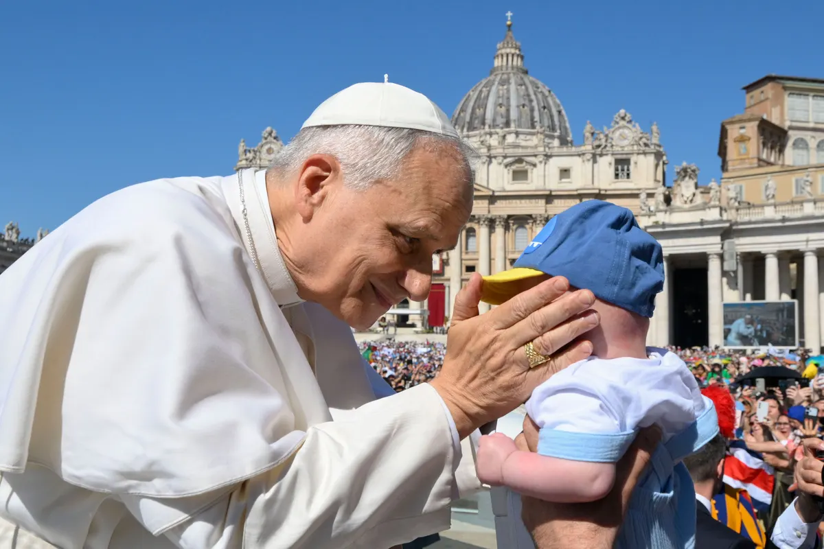 Papa Francesco accarezza un bambino in piazza San Pietro