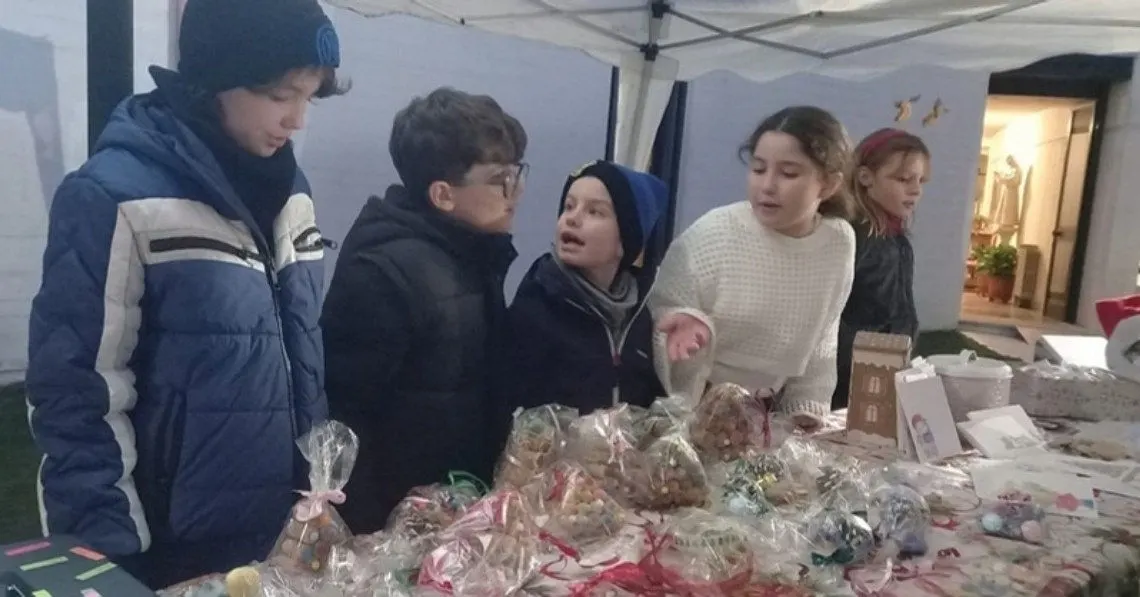 Ragazzi al banco dei dolci del mercatino di Natale della parrocchia