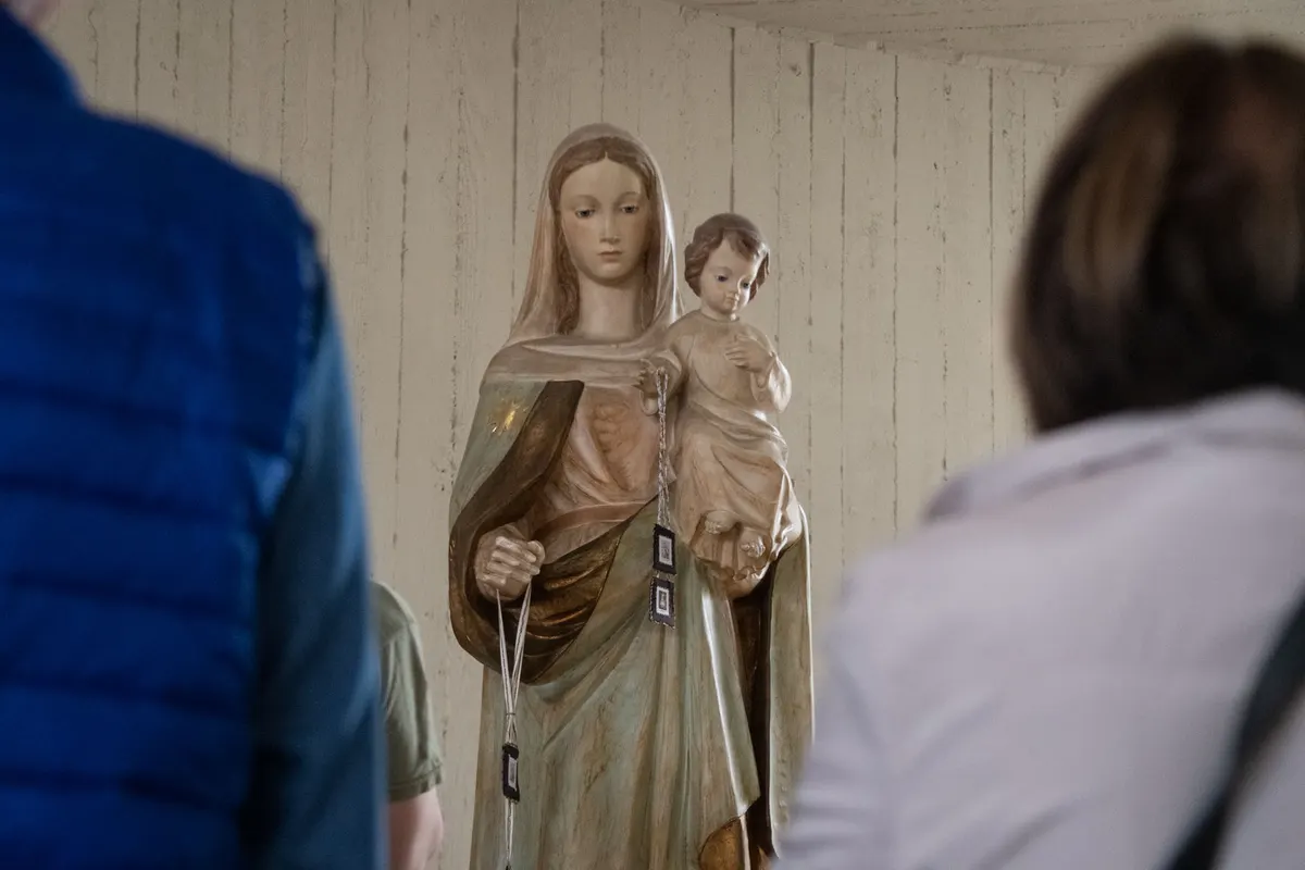 Statua della Madonna del Carmine con il Bambino tra i fedeli